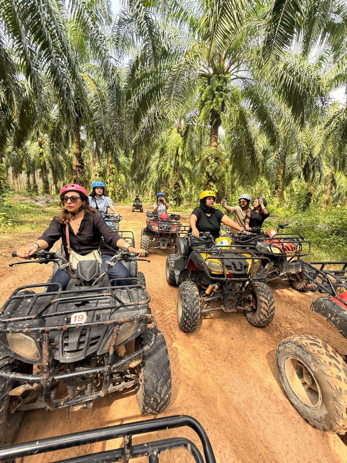ATV riders traveling through a palm forest trail