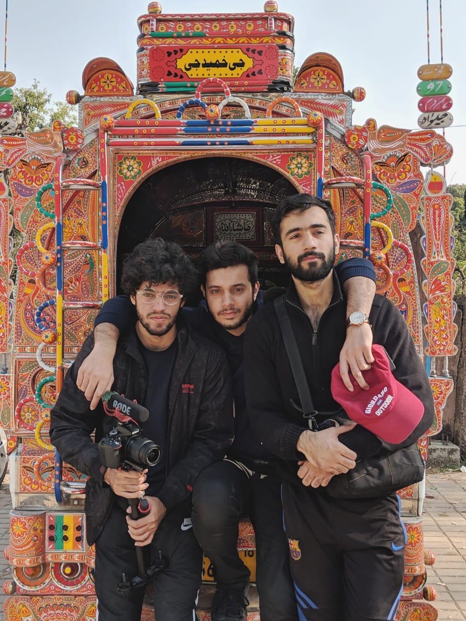 Three founders posing in front of a colorful decorated truck