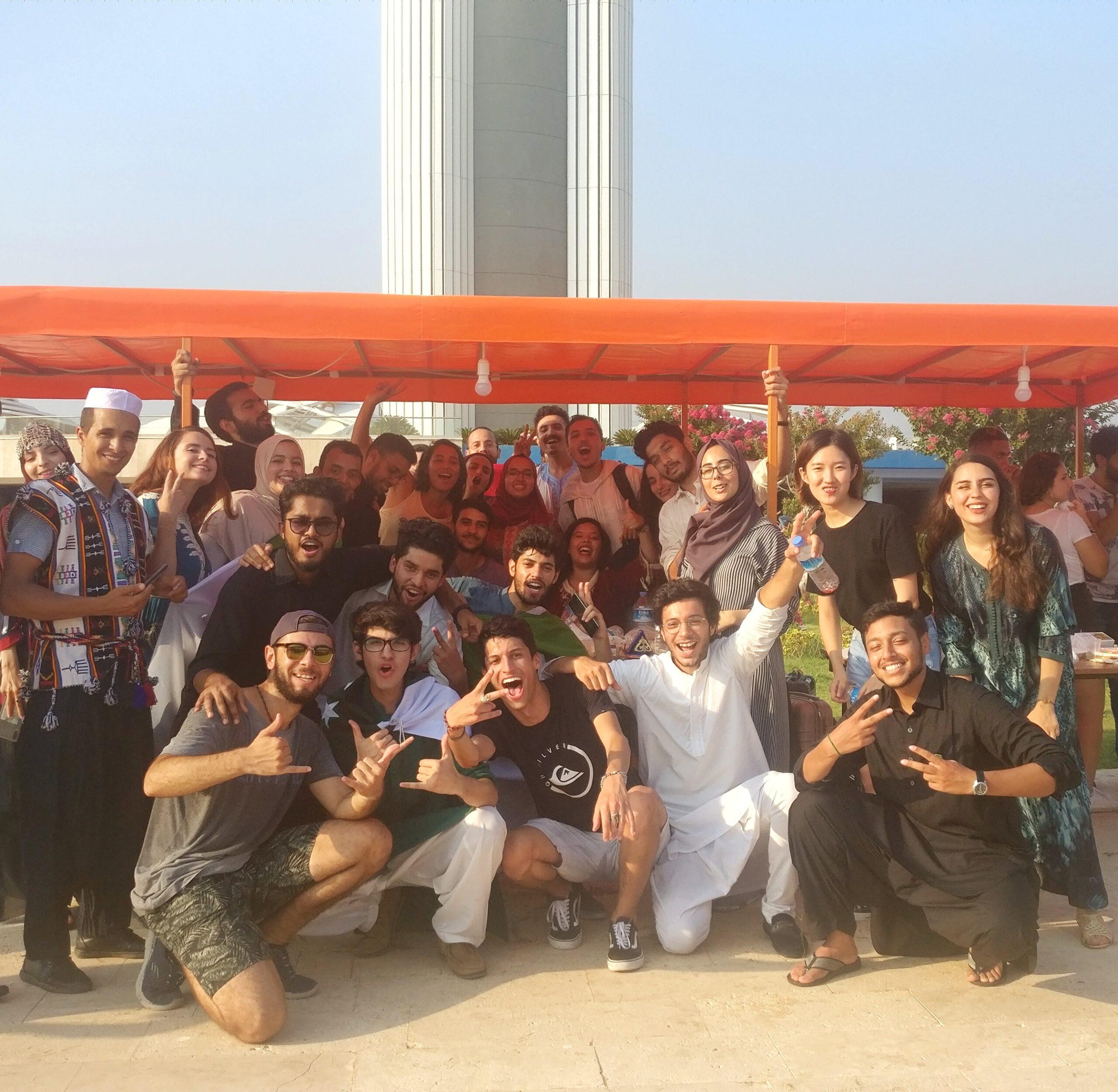 Large community gathering outdoors sharing smiles and conversation